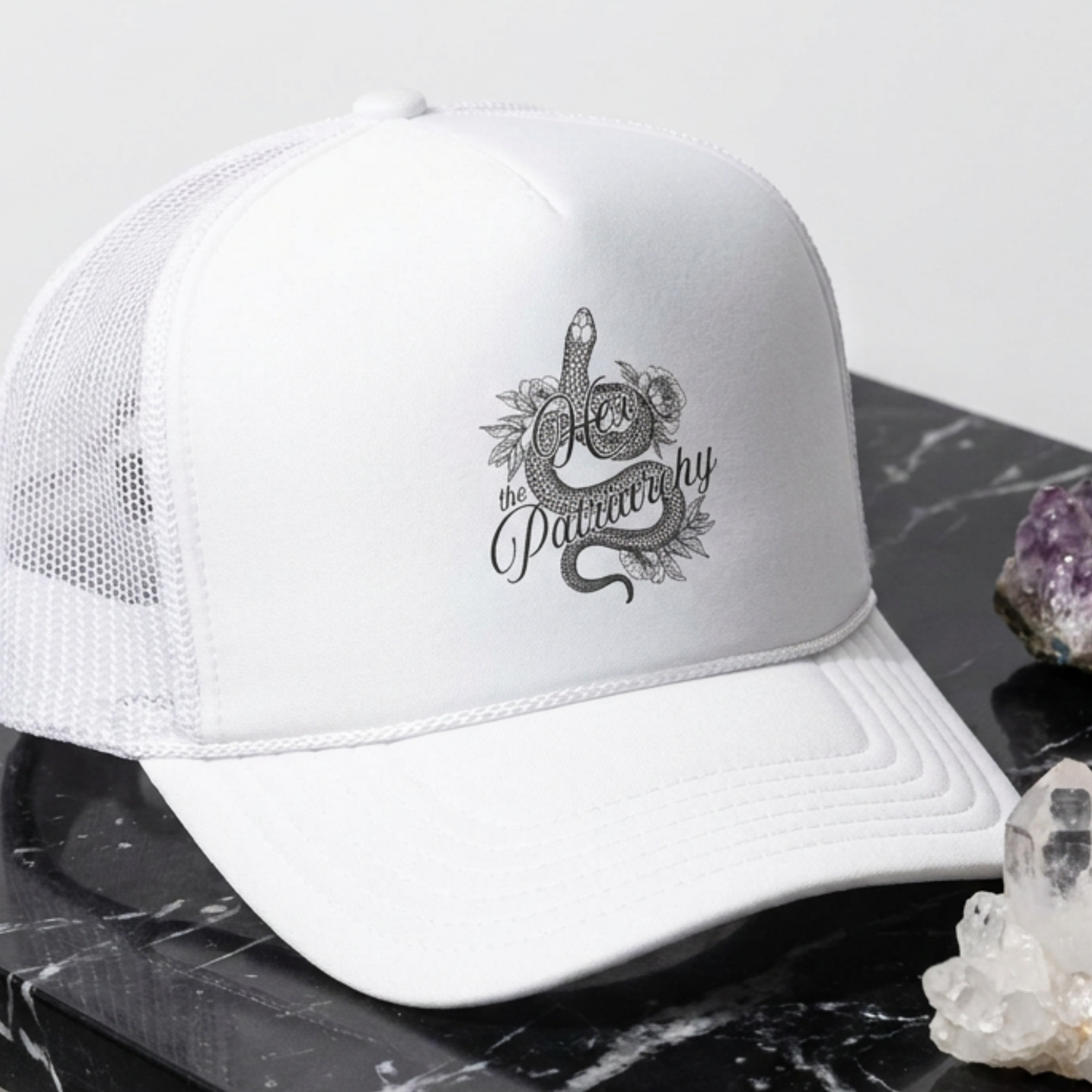Hex the Patriarchy snake trucker hat featuring feminist witchy artwork, classic mesh-back styling, and symbolic snake design.
