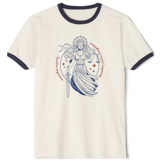 An off-white ringer t-shirt with dark navy blue trim on the collar and sleeves, featuring a central  red, white, and blue graphic of a female warrior holding a sword and shield, surrounded by red stars and circular text that reads: “Injustice anywhere threatens justice everywhere”