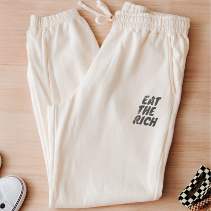 Eat the Rich zombie Halloween joggers with feminist political satire graphic, relaxed fleece fit, drawstring waist, and spooky season style.