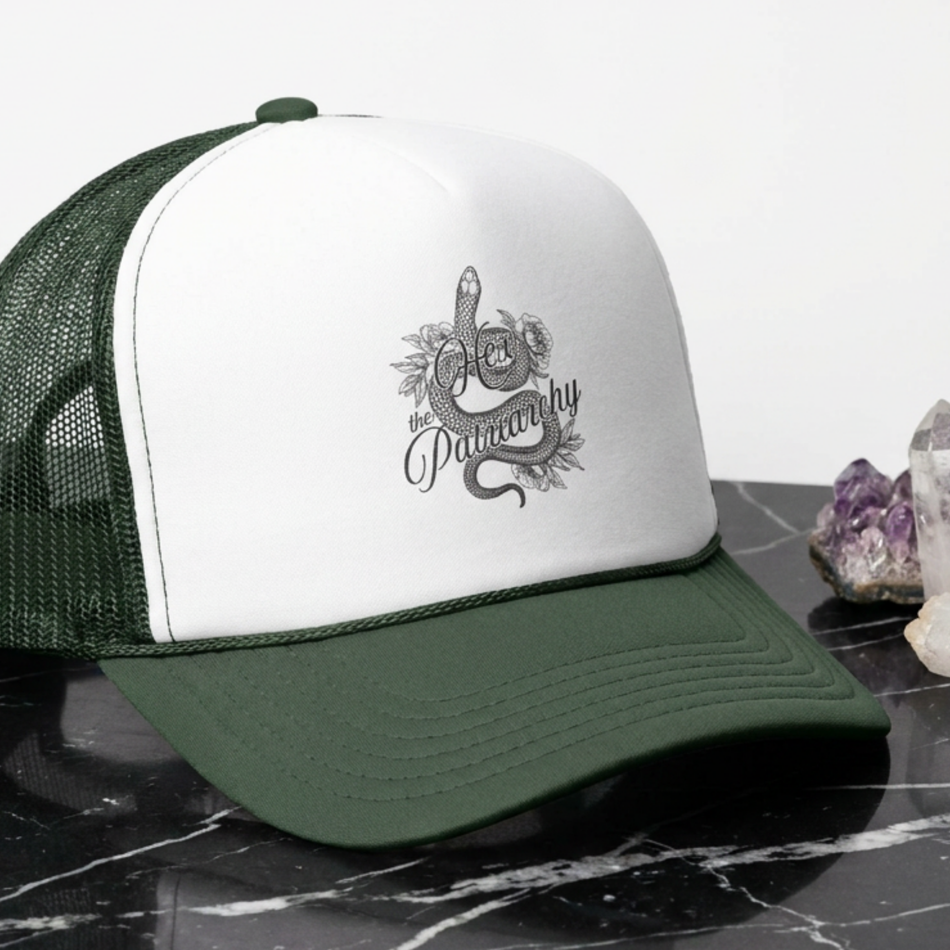 Hex the Patriarchy snake trucker hat featuring feminist witchy artwork, classic mesh-back styling, and symbolic snake design.
