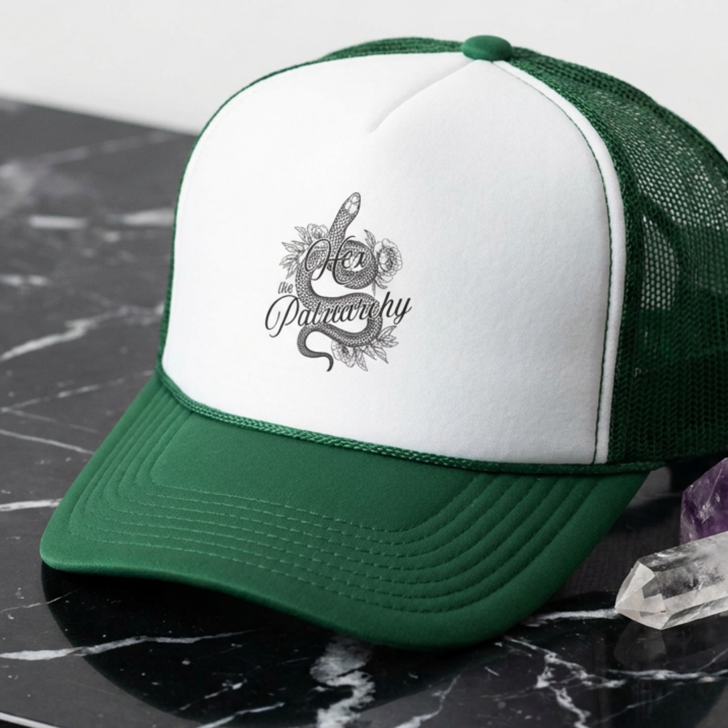 Hex the Patriarchy snake trucker hat featuring feminist witchy artwork, classic mesh-back styling, and symbolic snake design.