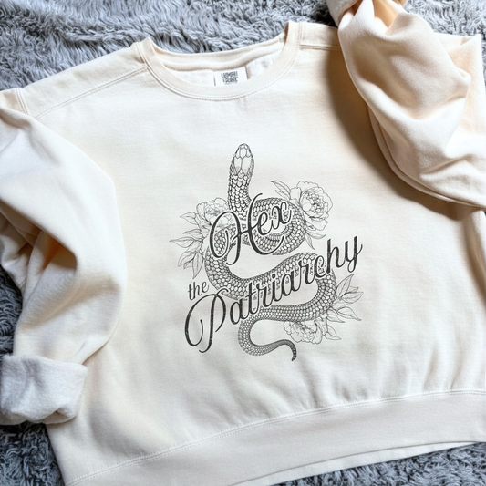 Hex the Patriarchy sweatshirt featuring a feminist snake design inspired by witchy symbolism, transformation, feminine power, and equality.