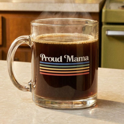 Clear mug with 'Proud Mama' design filled with coffee on a kitchen counter.