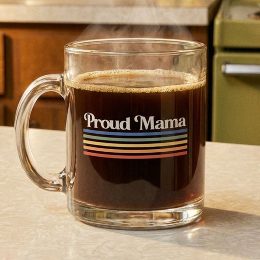 Clear mug with 'Proud Mama' design filled with coffee on a kitchen counter.